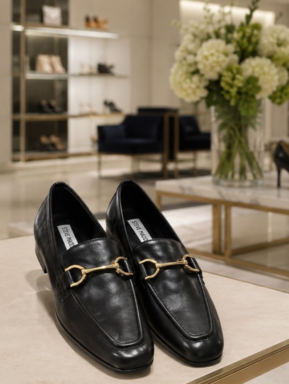 Steve Madden women's loafers in black with gold horsebit hardware.